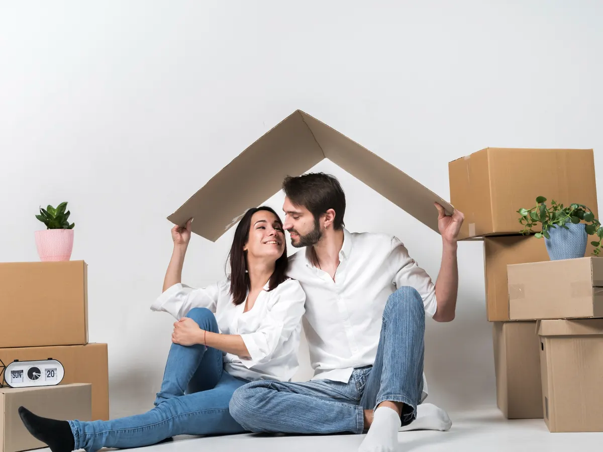 Pareja instalándose en su nueva vivienda entre cajas de mudanza